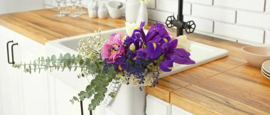 Sink with beautiful bouquet of fresh flowers in modern kitchen