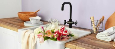 Ceramic sink with beautiful bouquet of flowers in modern kitchen