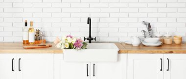 Clean sink with beautiful bouquet of flowers in interior of modern kitchen