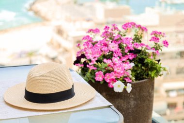 Table with summer hat on balcony, closeup