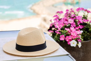 Table with summer hat on balcony, closeup