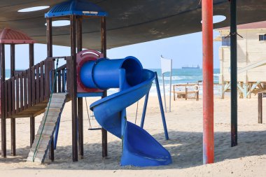 Children's playground with slide on beach