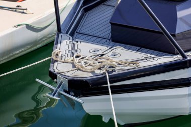 Modern yacht with rope in sea at pier, closeup