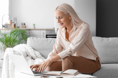 Mature woman using computer at home