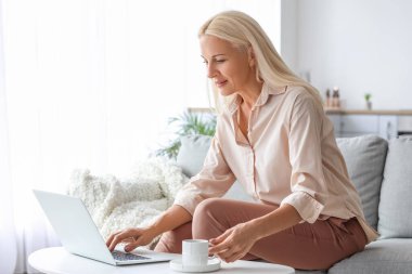 Mature woman using computer at home