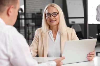 Mature bank manager working with client in office