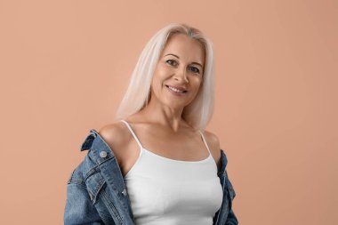 Mature blonde woman on beige background