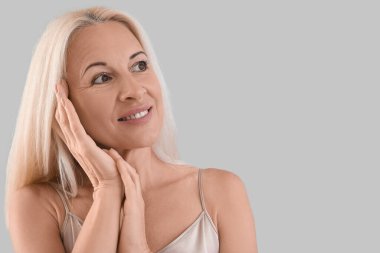 Mature blonde woman on light background