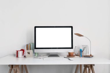 Işık duvarının yanında bilgisayar, bardak ve Noel hediyeli işyeri