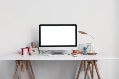 Işık duvarının yanında bilgisayar, bardak ve Noel hediyeli işyeri