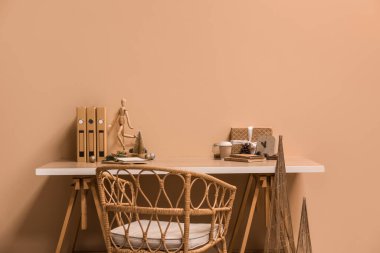 Noel dekoru, hediyesi, kahve fincanı ve bej duvarın yanındaki mankenli işyeri.