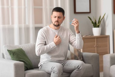 Sick man with inhaler at home