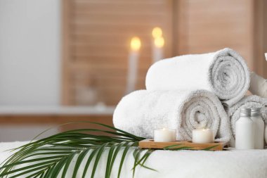 Spa composition with palm leaf on couch in salon, closeup