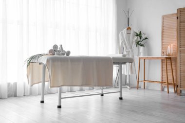 Interior of spa salon with couch, bathrobe and table