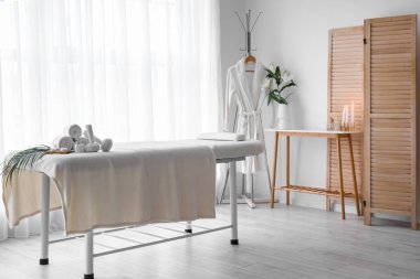 Interior of spa salon with couch, bathrobe and table