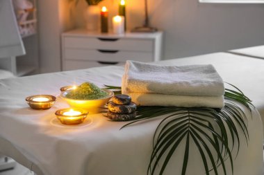 Spa composition with palm leaf on couch in salon, closeup