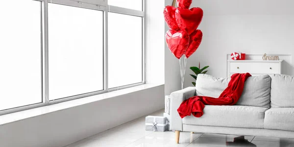 Interior of living room with red heart shaped balloons and sofa. Valentine\'s Day celebration