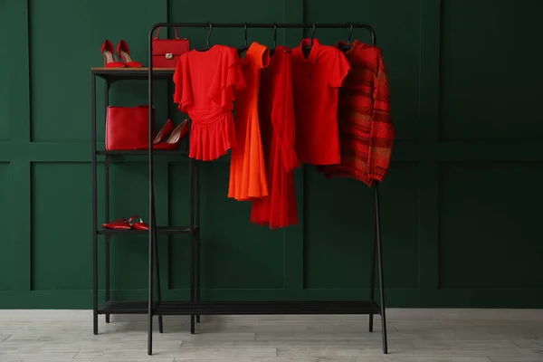 Стойка Красной Одеждой Полки Обувь Возле Зеленой Стены — стоковое фото