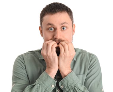 Gömlekli yakışıklı adam beyaz arka planda tırnak yiyor, yakın plan.