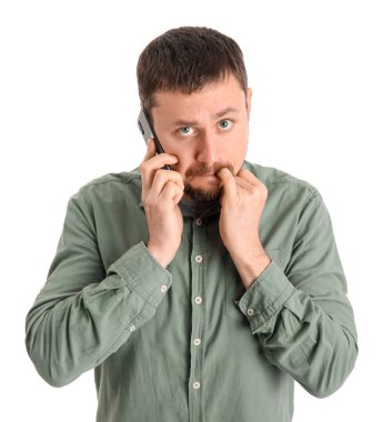 Tırnak yiyen ve beyaz arka planda cep telefonuyla konuşan yakışıklı bir adam.