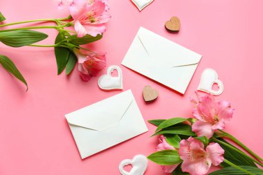 Composition with beautiful alstroemeria flowers, envelopes and decor on pink background. Mother's day celebration
