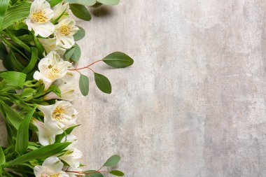 Fresh alstroemeria flowers and eucalyptus branches on grunge background