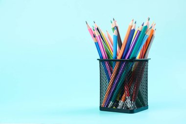 Stationery holder with pencils on blue background