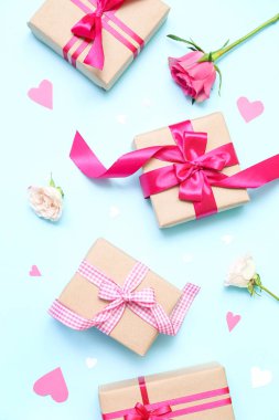 Composition with beautiful gift boxes, paper decor and flowers on color background. Valentine's Day celebration