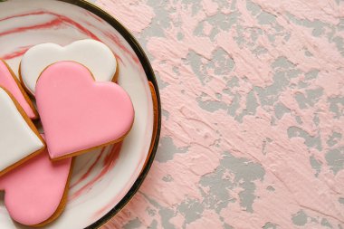 Plate with heart shaped cookies on pink grunge background, closeup. Valentines Day celebration