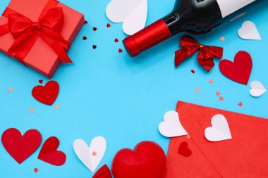 Frame made with bottle of wine, gift, envelope and decor on color background. Valentines Day celebration