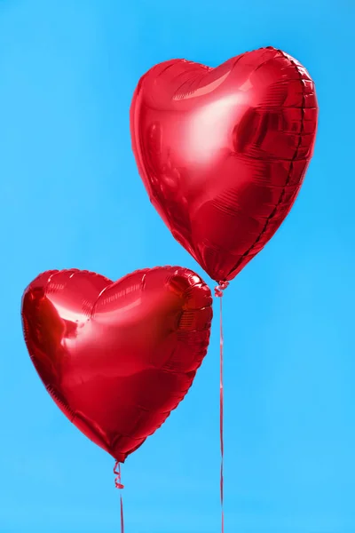 Heart-shaped balloons for Valentine\'s Day on blue background