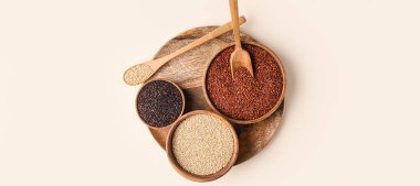 Different healthy quinoa on light background, top view
