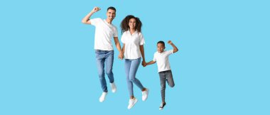 Happy jumping interracial family on light blue background clipart