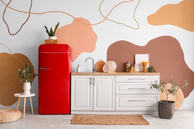 Interior of stylish kitchen with retro fridge, counters and houseplants