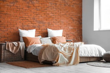 Interior of bedroom with big bed, table and basket