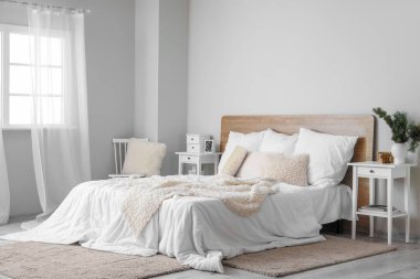 Interior of light bedroom with white tables and chair