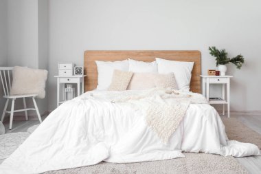 Interior of light bedroom with white tables and chair