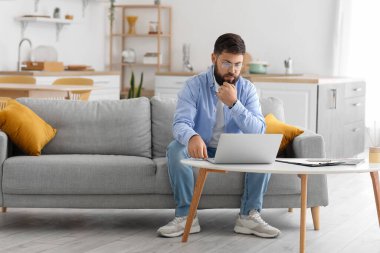 Dizüstü bilgisayarı olan erkek psikolog evde hastayla sohbet ediyor.