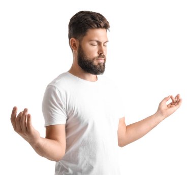 Handsome bearded man meditating on white background