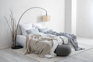 Interior of modern bedroom with lamp and tree branches