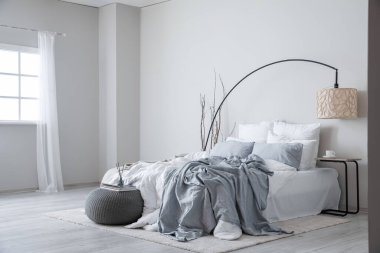 Interior of modern bedroom with lamp and tree branches