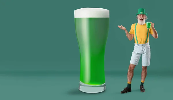 Senior man and big glass of beer on green background. St. Patrick\'s Day celebration