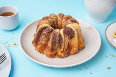 Plate with delicious cake on blue background