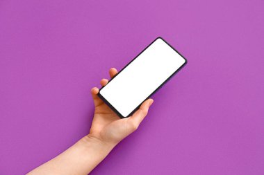Female hand with modern mobile phone on purple background, closeup
