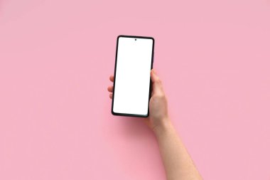 Female hand with modern mobile phone on pink background, closeup