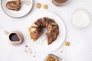Plate with delicious cake and hot chocolate on light background