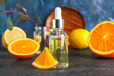 Bottle of healthy serum and fresh citrus fruits on table