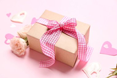 Gift box with roses and hearts for Valentine's Day on pink background, closeup