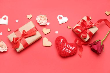 Gift boxes with hearts and roses for Valentine's Day on red background