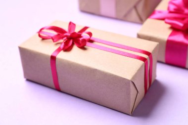 Beautiful gifts for Valentine's Day celebration on lilac background, closeup